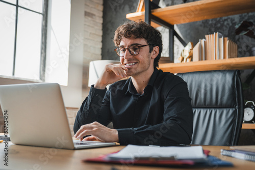 Office, laptop and man with glasses, happy and risk assessment for investment proposal and research. Business, financial analyst and person with tech for asset management, smile and budget review