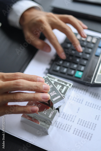 Silver Bullion Investment and Financial Analysis. Businessman Calculating Investment Returns with Silver Bars and Financial Documents.