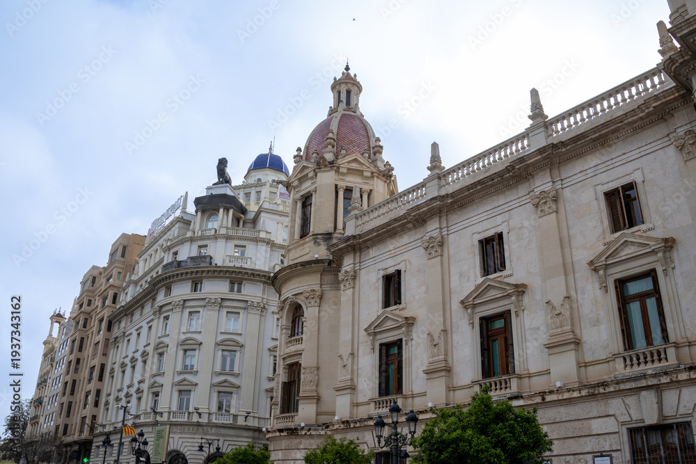 Fototapeta premium Valencia City Hall in Plaza del Ayuntamiento during Fallas. Crowds gather for the Mascletà, a thunderous firework show, safely watched from behind the protective cage