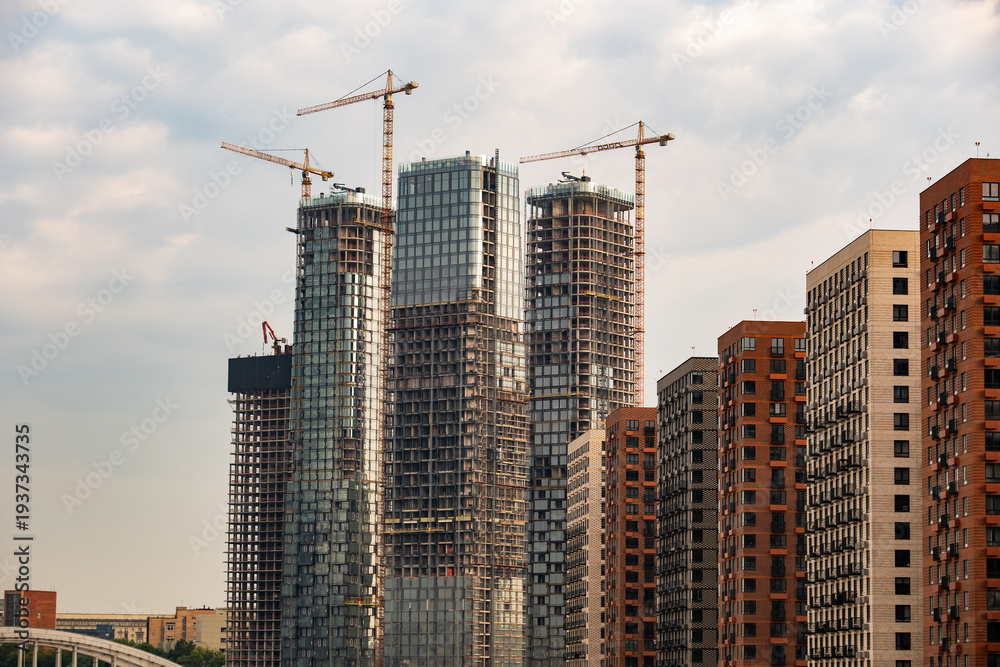 Fototapeta premium City skyline with new skyscrapers constructing next to modern residential buildings