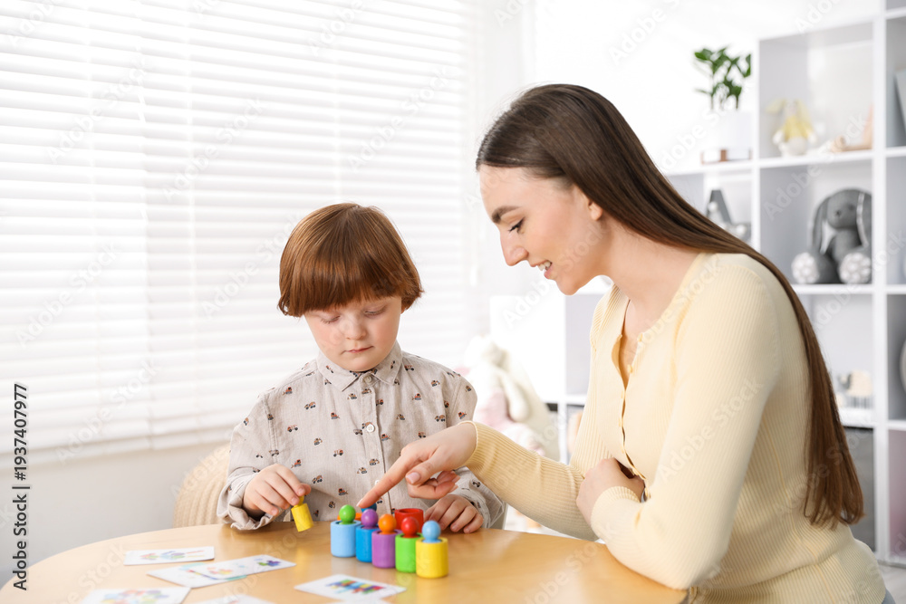 Obraz premium Mother and her son playing with toys on wooden table indoors