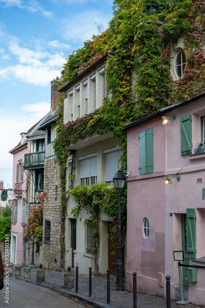 Fototapeta premium Walking on Montmartre hilly historical artistic district of Paris with famous buildings and narrow streets, tourists destination in France