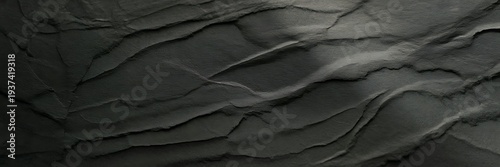 A close up view of a dark gray slate texture with rough and uneven surface