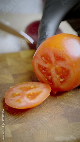 Chef cuts tomatoes. Professional chef carefully trims juicy tomatoes on wooden surface emphasizing cleanliness and precision during cooking