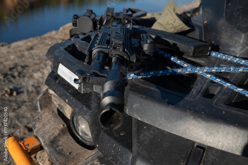 Modern Assault Rifle and Tactical Gear on ATV in Outdoor Terrain