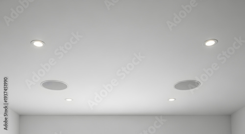 Modern white ceiling design featuring discreet recessed LED lighting and integrated in-ceiling speakers, creating a clean, minimalist, and technologically advanced interior aesthetic