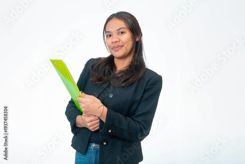 Portrait of smiling Indonesian woman wearing black blazer and white shirt, posing with fist under chin and looking at camera, isolated on white background.
