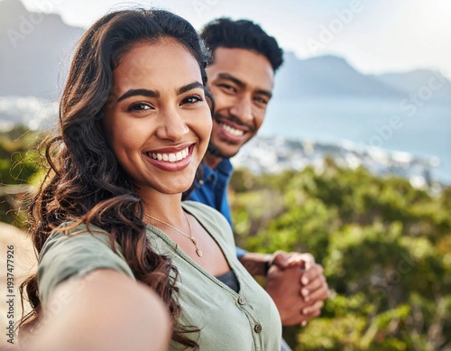 Happy couple taking a selfie with a beautiful mountain and ocean view.