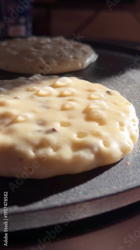 Close-up footage of pancake batter cooking in a hot pan, showing bubbles forming. Perfect for cooking tutorials, food preparation, and breakfast-related content.