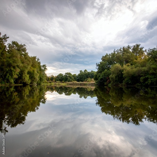 Serene River Reflection Under a Cloudy Sky.