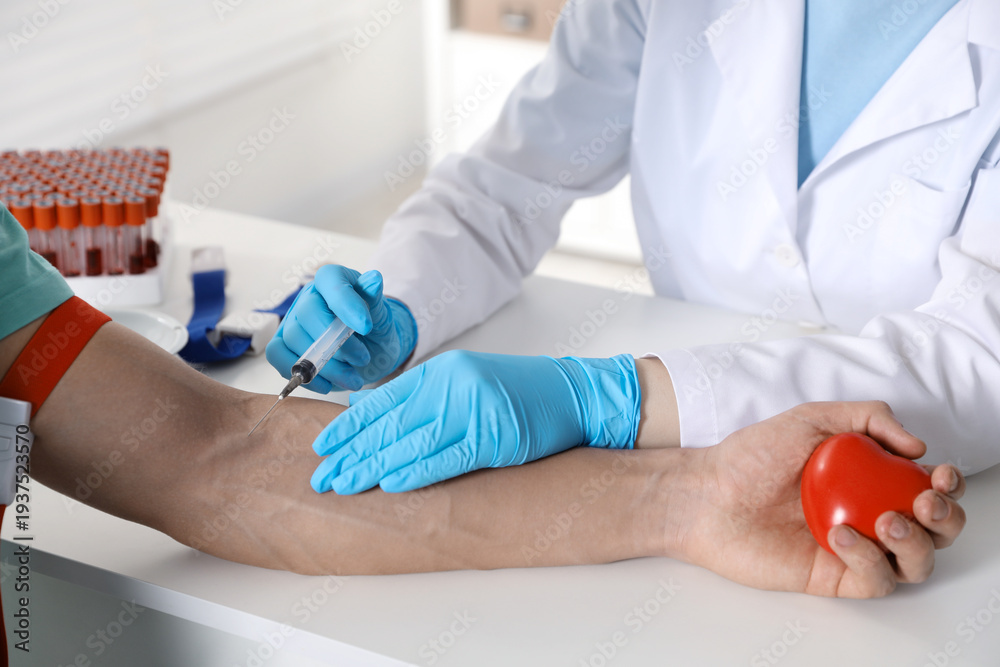 Obraz premium Doctor drawing man's blood sample in clinic, closeup
