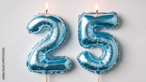 Blue number 25 candles lit for twenty-fifth birthday or anniversary