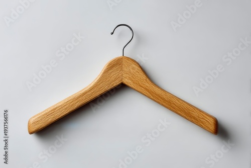 A single light-colored wooden hanger with a shiny metal hook is presented against a plain light background