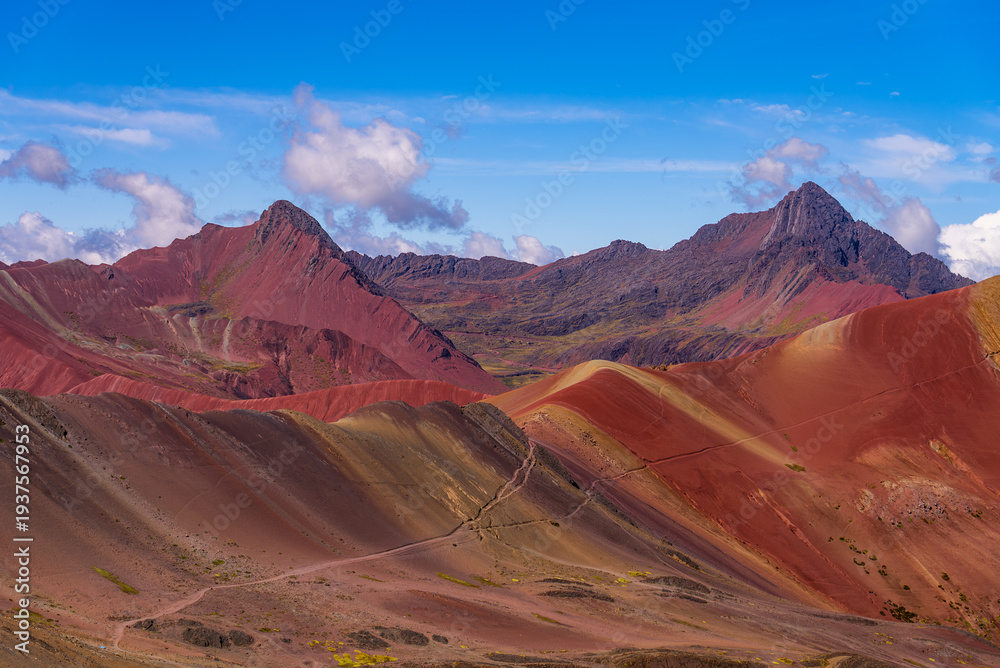 Fototapeta premium Rainbow Mountain trek Vinicunca seven colors siete colores montañas Peru Perú morning blue skies clouds fog movement Red Valley Peruvian Andes Mountains rainy dry season nature landscape
