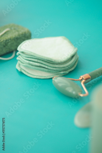 Quadro su tela Cotton pads and jade roller on turquoise background