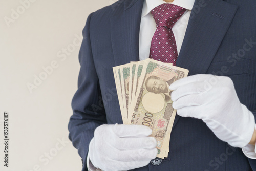 白手袋をはめて現金を数えるスーツ姿の男性