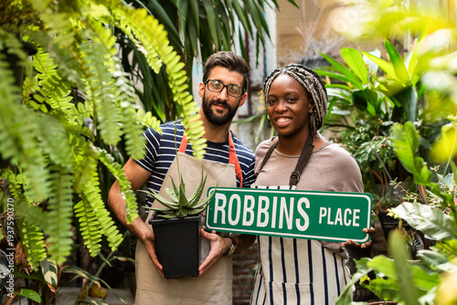 фотографія Gardeners holding sign smiling