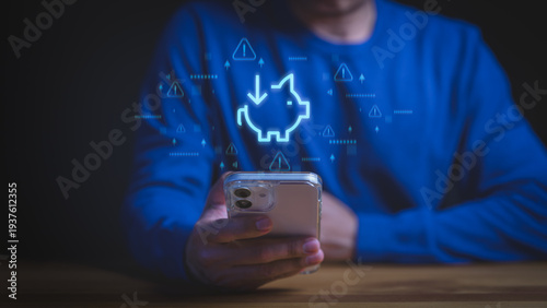 Financial crisis and declining savings concept. Man holding smartphone with piggy bank icon and warning alerts for economic loss, inflation, and investment risk in digital banking app.