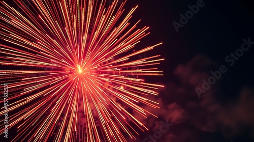 Vibrant red and orange fireworks exploding in a dark night sky, creating a spectacular burst of light and color for celebrations.