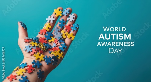 Hand with colorful puzzle pieces for world autism awareness day on blue background