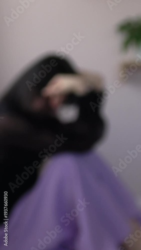 【縦動画】ぼかし背景素材: 部屋で一人、絶望し落ち込む女性　不安、孤独、うつ、メンタルヘルスイメージ