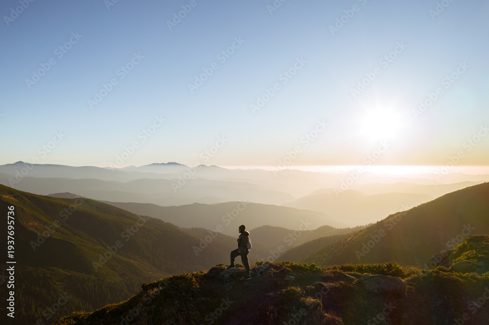 Fototapeta premium Aerial View of Hiker Man with Backpack on Top of a Mountain
