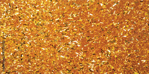 Close-up, high-angle view of vibrant golden glitter and confetti covering a surface, creating a rich, textured background for celebratory themes.