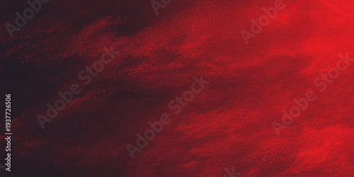 Dramatic red clouds fill the atmosphere during a dark storm sunset creating an abstract nature cloudscape across the fiery sky