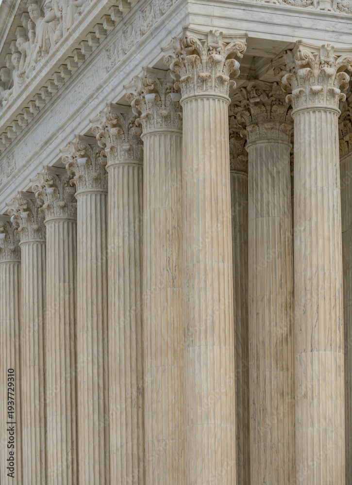 Fototapeta premium Columns stone facade architectural symmetry. Columns marble fluted pattern. Columns decorative capitals carved detail. Columns classical.