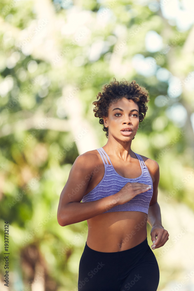 Naklejka premium Woman, running and exercise at park in city for fitness, cardio and outdoor for wellness in summer. Person, training and runner with workout, benefits or fast with breathing on road in urban town