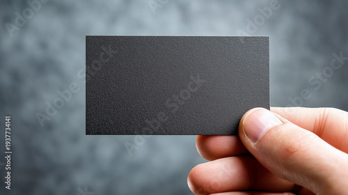 Hand holding blank black business card mockup