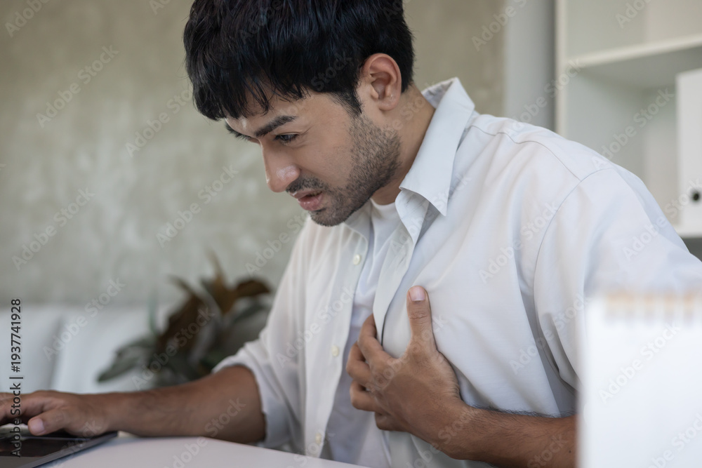 Fototapeta premium hand hold chest with heart attack symptoms, asian man have chest pain caused by heart disease, leak, dilatation, enlarged coronary heart, press on the chest with a painful expression