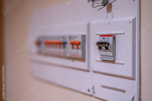 Electrical circuit breakers panel with a tripped switch, indicating an overload or power failure, representing concepts of electricity disruption, security, and maintenance