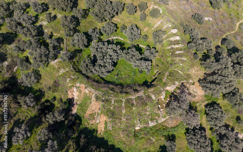 Aerial drone view of Mastaura Antik Kenti in Aydin, Turkey, showcasing ancient ruins, the well-preserved Roman amphitheater, and surrounding landscape from above.