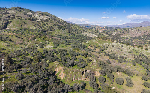 Aerial drone view of Mastaura Antik Kenti in Aydin, Turkey, showcasing ancient ruins, the well-preserved Roman amphitheater, and surrounding landscape from above.