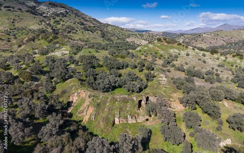 Aerial drone view of Mastaura Antik Kenti in Aydin, Turkey, showcasing ancient ruins, the well-preserved Roman amphitheater, and surrounding landscape from above.