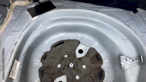 A car’s trunk usually has a circular recessed metal section designed to hold the spare tire and tools.