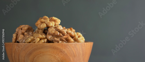 Walnuts in wooden bowl on neutral background healthy food concept