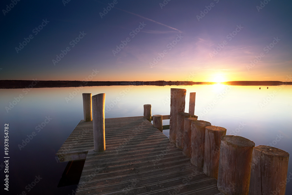 Obraz premium beautiful sunset on the beach near the wooden pier