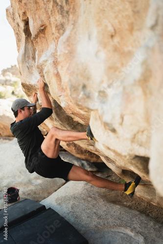 Climber placing foothold while bouldering in Joshua Tree desert