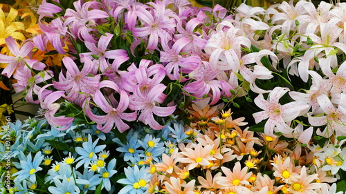 Schilderij op canvas Colorful artificial flowers on display in a flower shop