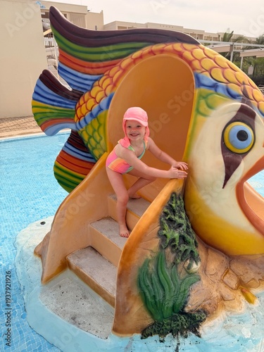 Tablou pe pânză Enfant descendant un toboggan aquatique coloré dans une piscine d’hôtel