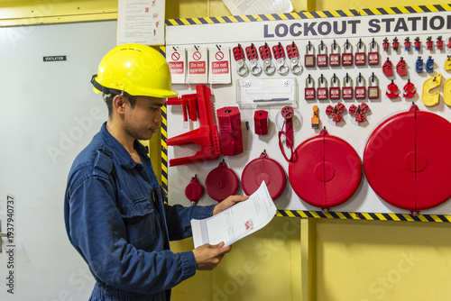 Professional seafarer following strict industrial safety procedures at a lockout tagout station on board vessel.