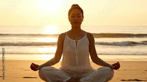 Asian Woman Meditating on Beach at Sunset in White Outfit with Golden Light and Ocean Waves in Background