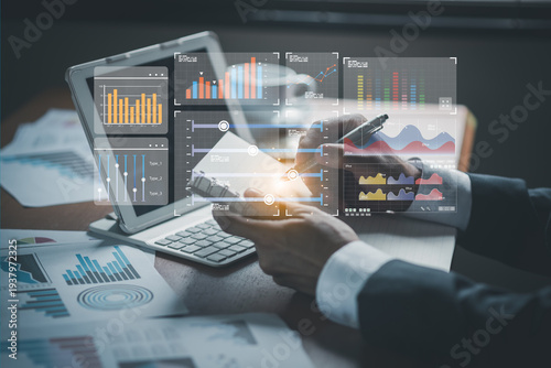 Businessman writing in notebook with pen while analyzing virtual financial bar charts and data statistics overlay