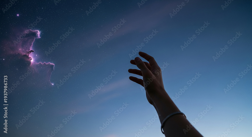Fototapeta premium A dark hand reaches for a colorful nebula in a starry night sky, representing aspiration, longing, and a connection to the vastness of the universe