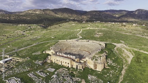 Cinematic aerial drone video of Hierapolis Antik Kenti and Pamukkale travertines in Denizli, Turkey, showcasing the Roman theater, columns, ruins, and dramatic landscape from above.