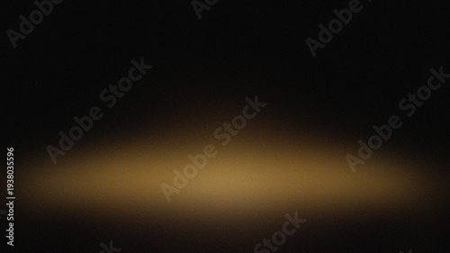 A soft golden light illuminates a dark and blurred background