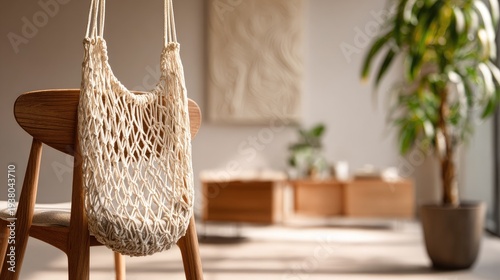 Eco-Friendly Reusable Mesh Bag Hanging on Wooden Chair in Sunny Room.