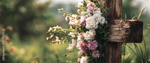 Wooden cross adorned with beautiful flowers representing faith, remembrance, love, and spiritual hope in nature